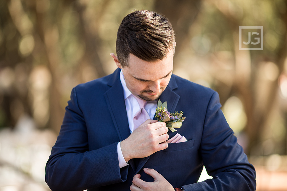 Groom adjusting his boutonnière