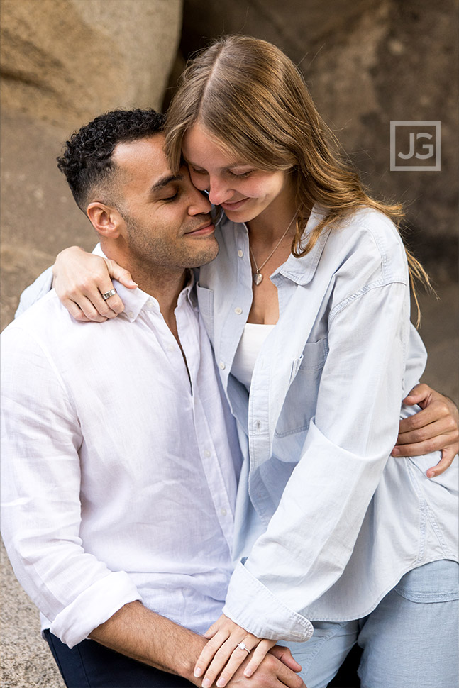 Couple cuddling surrounded by rocks